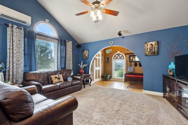 living area featuring plenty of natural light, arched walkways, ceiling fan, and a wall mounted AC