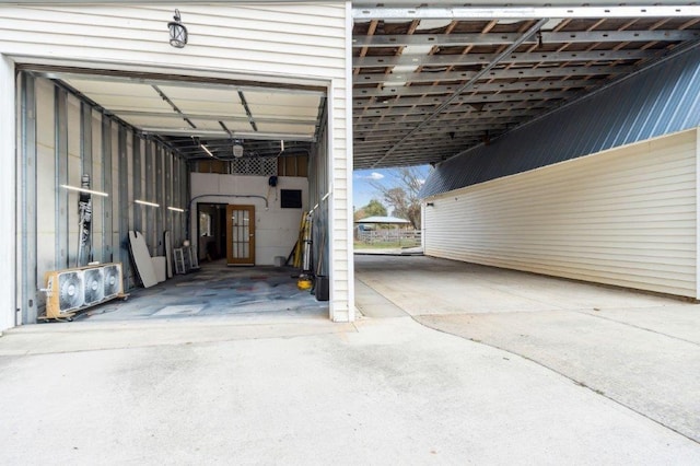 garage featuring driveway and an attached carport