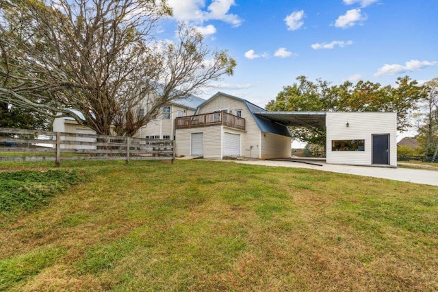 exterior space with driveway, a front yard, fence, an outdoor structure, and a gambrel roof