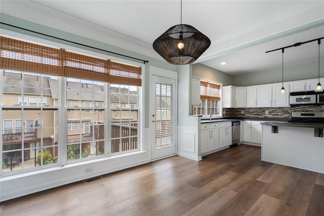 4855 Payson Ter SE Unit 3, Atlanta, GA 30339 - kitchen with stainless steel appliances, dark wood-type flooring, white cabinets, dark countertops, and decorative light fixtures