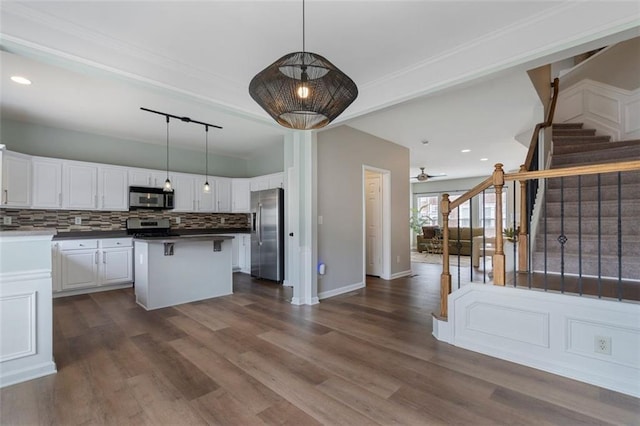 4855 Payson Ter SE Unit 3, Atlanta, GA 30339 - kitchen featuring stainless steel appliances, white cabinetry, backsplash, open floor plan, and dark wood finished floors