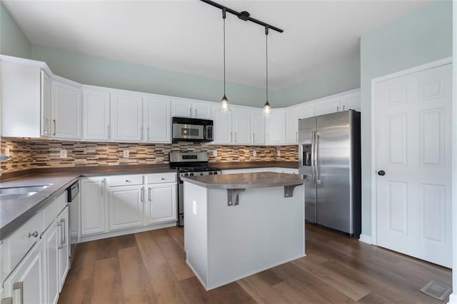 4855 Payson Ter SE Unit 3, Atlanta, GA 30339 - kitchen with appliances with stainless steel finishes, dark countertops, white cabinetry, and backsplash