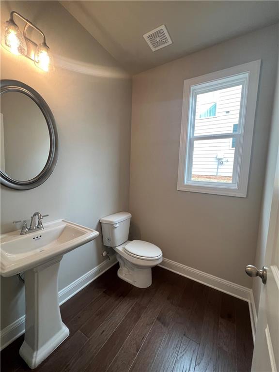 bathroom featuring toilet and wood-type flooring