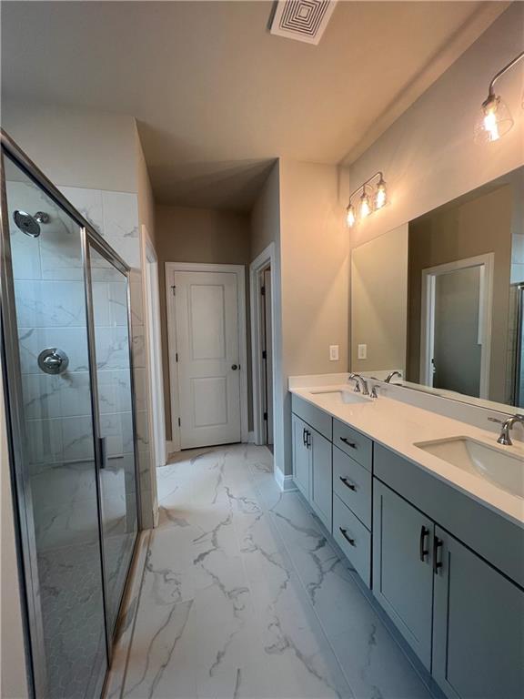 bathroom with vanity and a shower with shower door