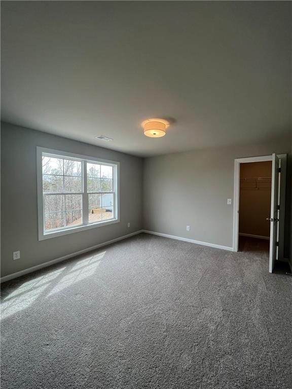 unfurnished room featuring dark colored carpet