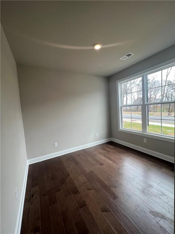 unfurnished room with dark hardwood / wood-style flooring