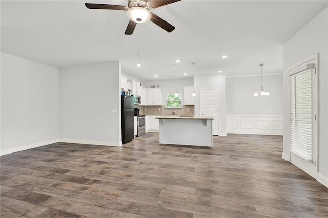 509 Grace Ln, Villa Rica, GA 30180 - unfurnished living room featuring a ceiling fan, dark wood-type flooring, recessed lighting, a chandelier, and a wainscoted wall