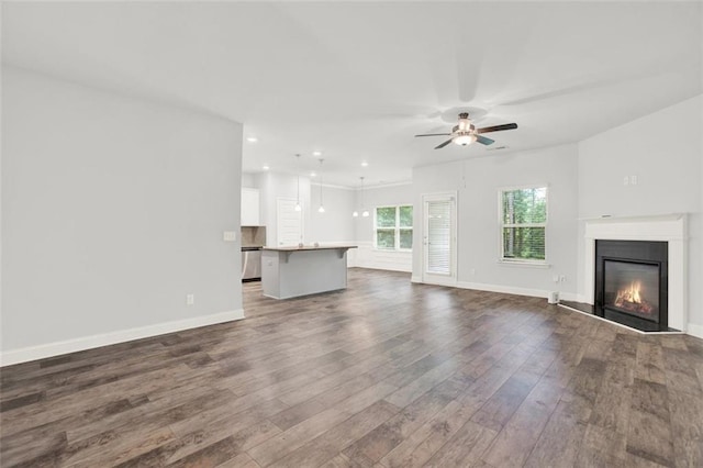 509 Grace Ln, Villa Rica, GA 30180 - unfurnished living room featuring dark wood-style floors, ceiling fan, recessed lighting, and a glass covered fireplace