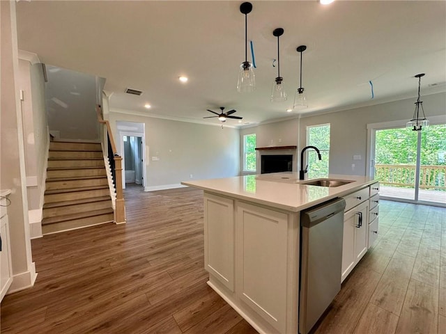 kitchen featuring visible vents, crown molding, dishwasher, a sink, and white cabinets