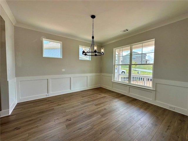 unfurnished dining area with crown molding, a notable chandelier, dark wood-style floors, and visible vents