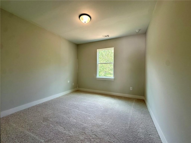 spare room with carpet floors, baseboards, and visible vents