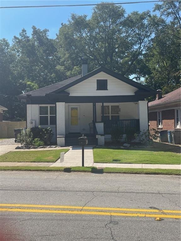 bungalow-style house with a porch and a front yard