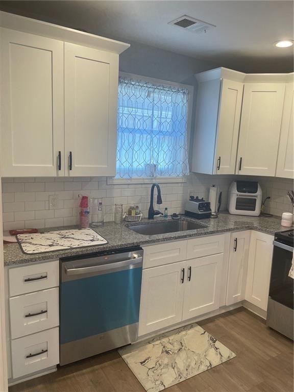 kitchen featuring backsplash, sink, white cabinetry, and stainless steel appliances