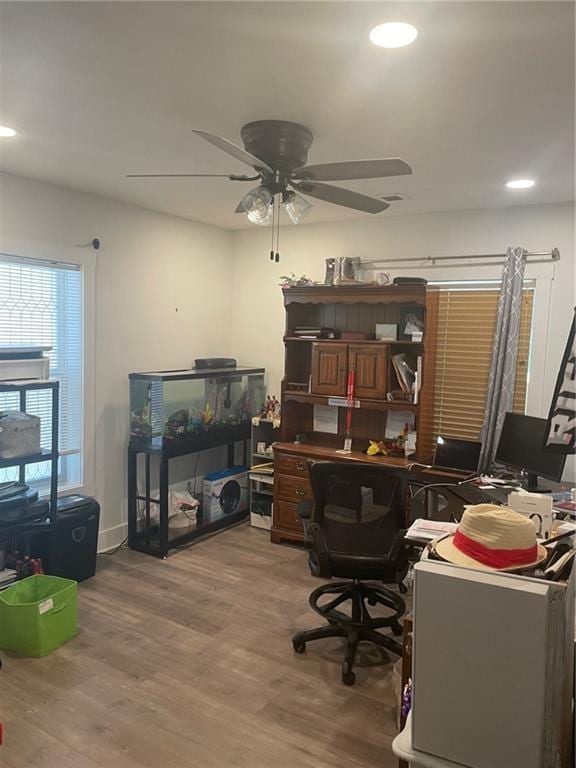 office space featuring ceiling fan and light hardwood / wood-style floors