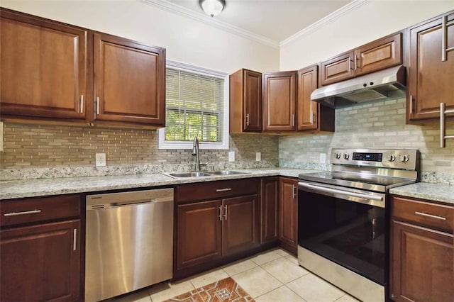 kitchen with appliances with stainless steel finishes, decorative backsplash, sink, and light tile patterned floors