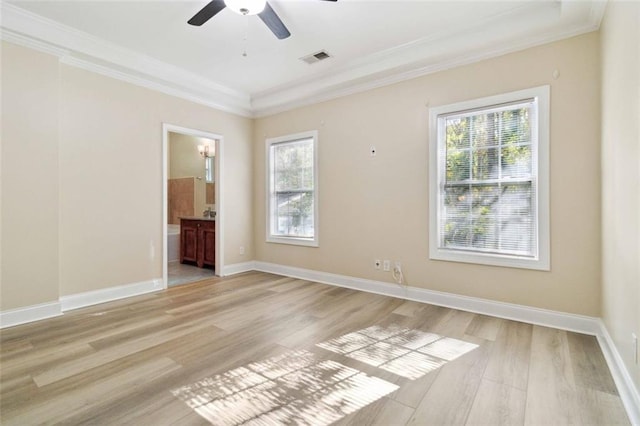 spare room featuring crown molding, light hardwood / wood-style flooring, and plenty of natural light