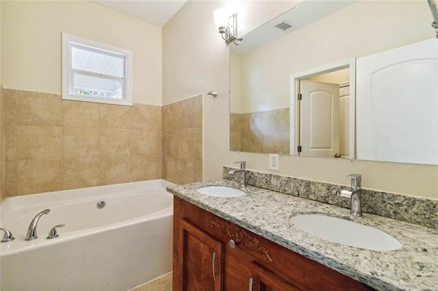 bathroom featuring vanity and a bath