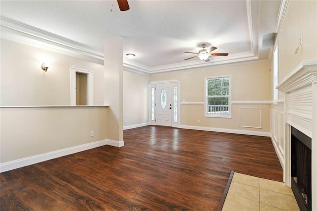 unfurnished living room with crown molding, ceiling fan, and dark hardwood / wood-style flooring