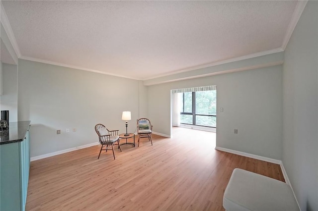 1800 Clairmont Lk Unit 313, Decatur, GA 30033 - sitting room featuring a textured ceiling, light wood finished floors, ornamental molding, and baseboards