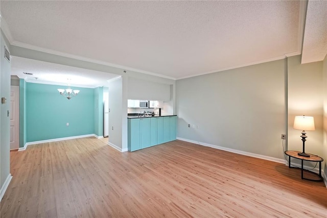 1800 Clairmont Lk Unit 313, Decatur, GA 30033 - unfurnished living room with a chandelier, light wood-type flooring, crown molding, baseboards, and a textured ceiling