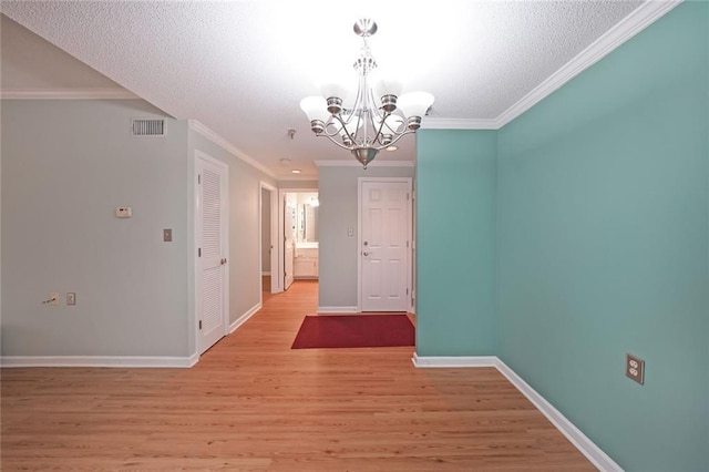 1800 Clairmont Lk Unit 313, Decatur, GA 30033 - unfurnished dining area with a chandelier, light wood finished floors, baseboards, ornamental molding, and a textured ceiling