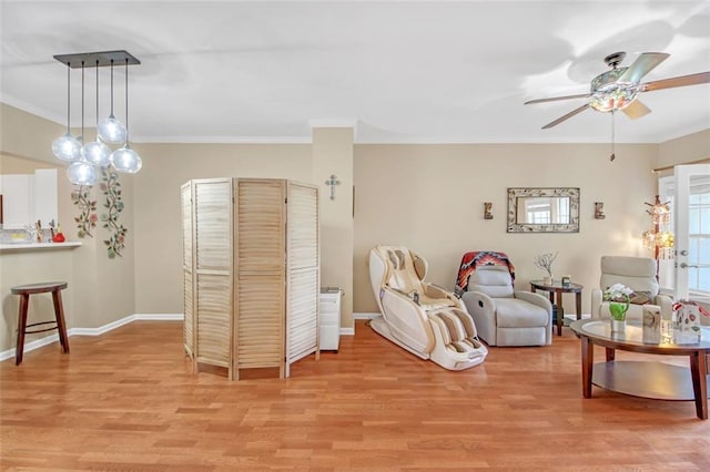 living room featuring ceiling fan, ornamental molding, and light hardwood / wood-style flooring