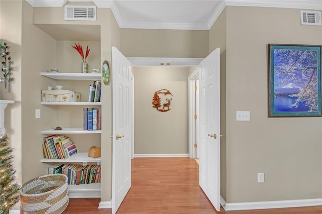 hallway featuring light wood-type flooring and ornamental molding