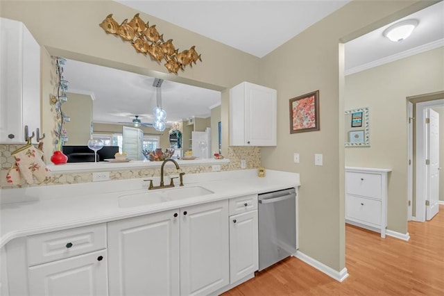 kitchen featuring pendant lighting, white cabinets, sink, stainless steel dishwasher, and light wood-type flooring