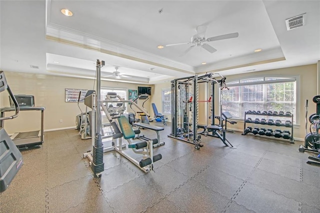 exercise room featuring ceiling fan, a raised ceiling, and crown molding