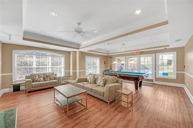 recreation room with a tray ceiling, light hardwood / wood-style flooring, ceiling fan, and pool table