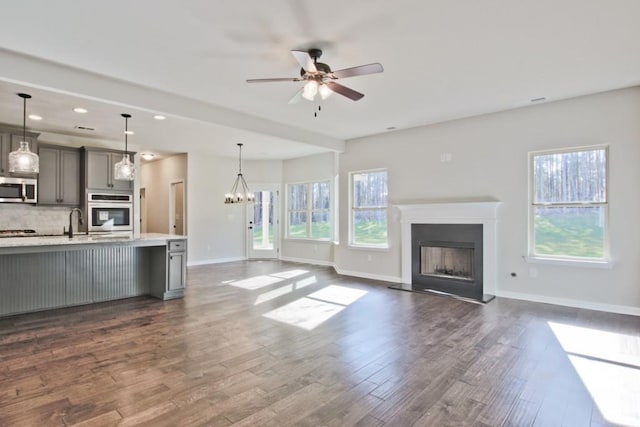 238 Linford Dr, Locust Grove, GA 30248 - unfurnished living room featuring a fireplace with raised hearth, plenty of natural light, dark wood finished floors, a ceiling fan, and recessed lighting