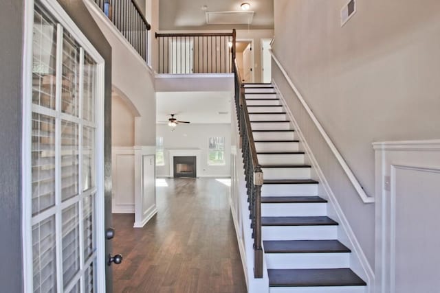 238 Linford Dr, Locust Grove, GA 30248 - stairs with a high ceiling, a fireplace, wood finished floors, ceiling fan, and arched walkways