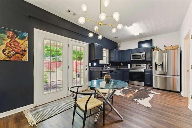 1689 Camden Forrest Way, Riverdale, GA 30296 - kitchen with stainless steel appliances, wood finished floors, a chandelier, a textured ceiling, and a sink