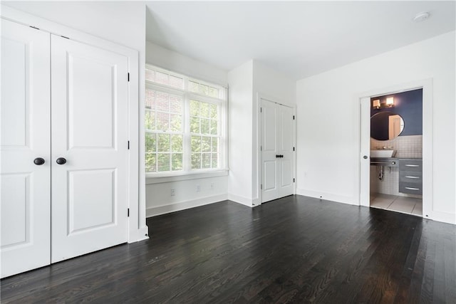 unfurnished bedroom with dark hardwood / wood-style flooring and ensuite bath