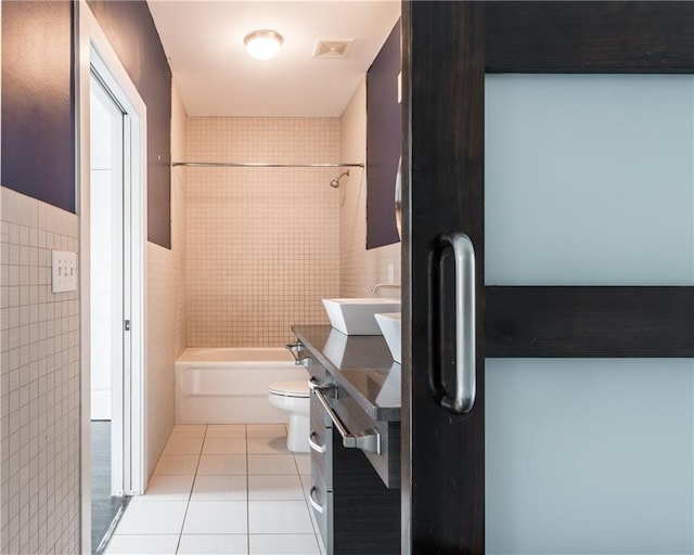 full bathroom with vanity, tile patterned floors, toilet, tile walls, and shower / bathtub combination