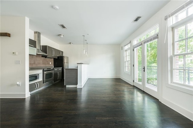 kitchen with backsplash, a wealth of natural light, dark hardwood / wood-style flooring, and oven