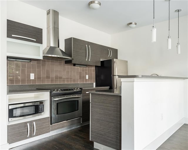 kitchen featuring decorative backsplash, wall chimney exhaust hood, stainless steel appliances, dark wood-type flooring, and hanging light fixtures