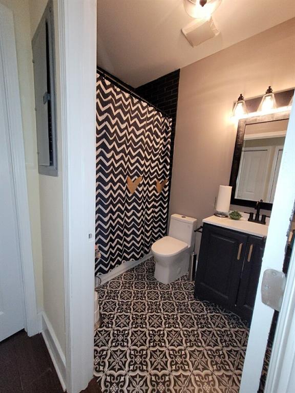 bathroom with vanity, tile patterned floors, electric panel, and toilet