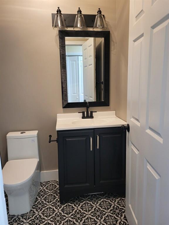 bathroom with vanity, toilet, and tile patterned floors