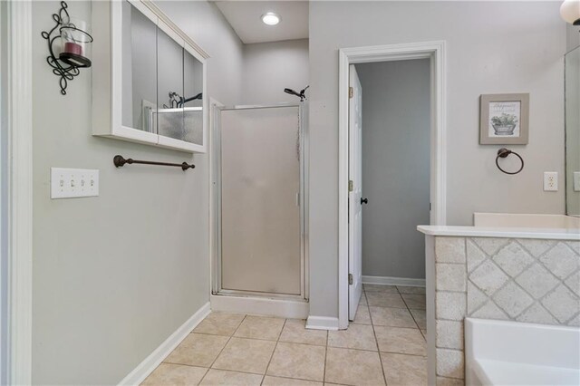 full bath featuring baseboards, tile patterned floors, a garden tub, and a stall shower