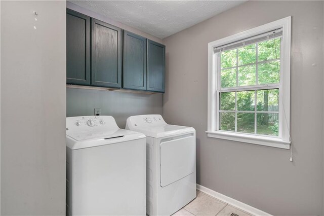laundry room with light tile patterned floors, independent washer and dryer, cabinet space, and a wealth of natural light
