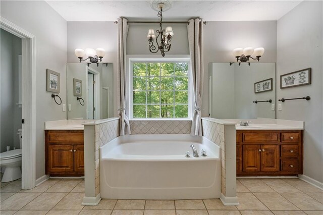 full bathroom featuring vanity, a garden tub, tile patterned floors, and a chandelier