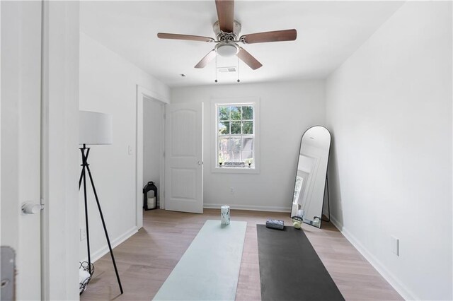 exercise area featuring ceiling fan and light hardwood / wood-style floors