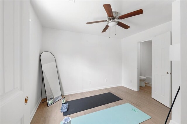 workout room with ceiling fan and light hardwood / wood-style floors