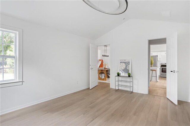 interior space with light hardwood / wood-style floors and vaulted ceiling