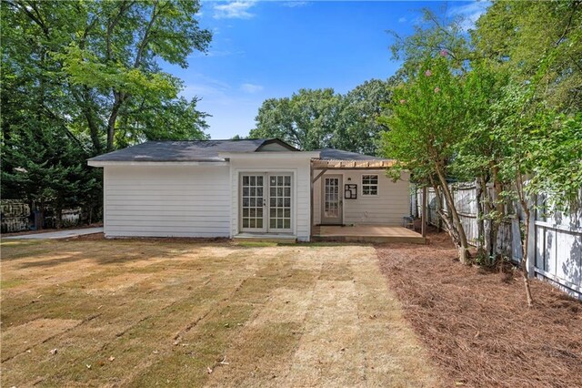 rear view of property with a lawn, a patio area, and french doors