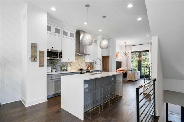 2328 Mason Dr, Atlanta, GA 30316 - kitchen with wall chimney range hood, stainless steel microwave, a sink, dark wood-style flooring, and backsplash