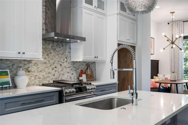 2328 Mason Dr, Atlanta, GA 30316 - kitchen featuring hanging light fixtures, wall chimney exhaust hood, a chandelier, stainless steel gas range oven, and decorative backsplash