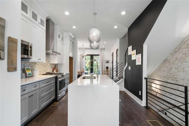 2328 Mason Dr, Atlanta, GA 30316 - kitchen with dark wood-type flooring, appliances with stainless steel finishes, a sink, and wall chimney exhaust hood