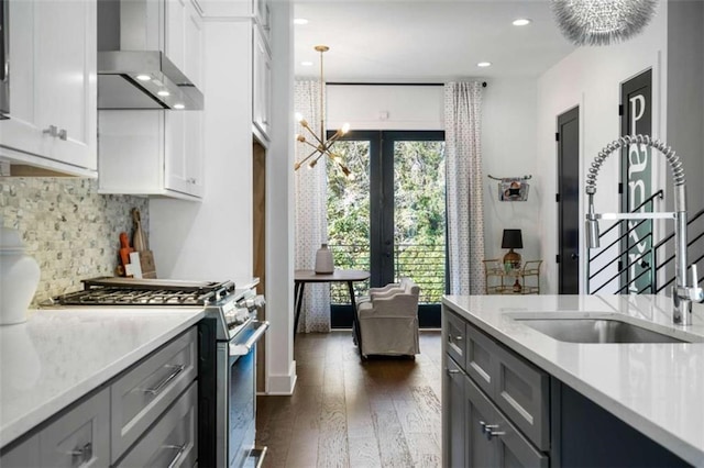 2328 Mason Dr, Atlanta, GA 30316 - kitchen with wall chimney range hood, a notable chandelier, stainless steel gas stove, and gray cabinets